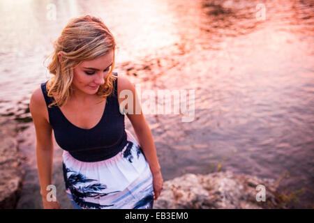 Caucasian ragazza adolescente permanente sulla riva Foto Stock