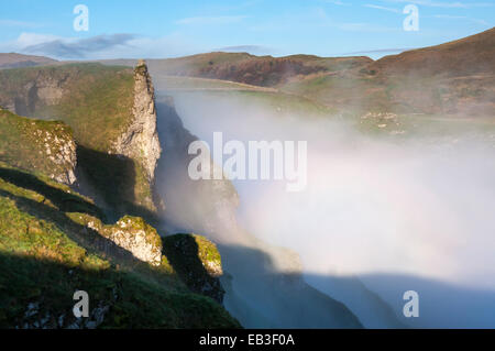 Drammatica nebbia di mattina a Winnats Pass nel Peak District, Derbyshire. Guardando verso Rushup edge. Foto Stock