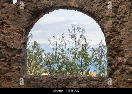 Antico in pietra finestra che mostra parte del paesaggio Foto Stock