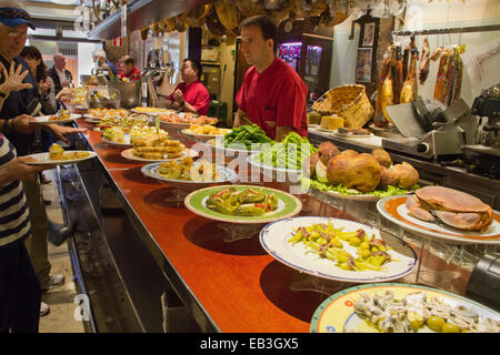 Piastre di tapas (pintxos in basco) sulla barra e ai clienti di ordinare solo ciò che vogliono San Sebastian,Spagna Foto Stock