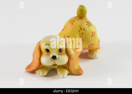 Statuetta di dog sitter su sfondo bianco, ceramica cane figurina Foto Stock