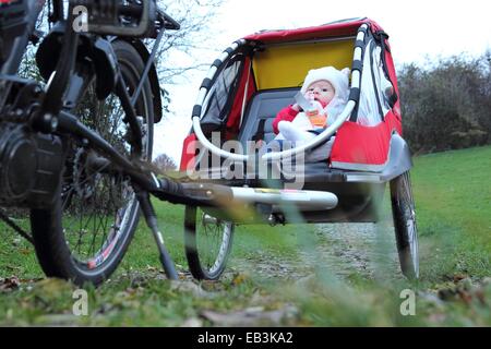 Un bambino in un bambino rimorchio bici Foto Stock