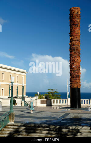 Donna che cammina dal Totem, Plaza V Centenario (Plaza del quinto centenario), la Città Vecchia di San Juan, Puerto Rico Foto Stock