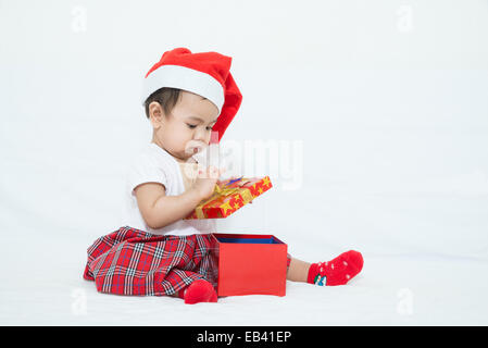 Bambino asiatico con il natale di apertura di coperchio scatola regalo Foto Stock