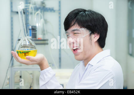 Ricercatore asiatica di effettuare esperimenti in un laboratorio - guardando sorpreso Foto Stock