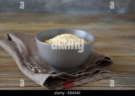Di semi di sesamo tostati in una ciotola su assi di legno, alimentari Foto Stock
