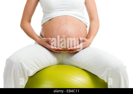 Donna incinta esercizi ginnici con sfera Foto Stock