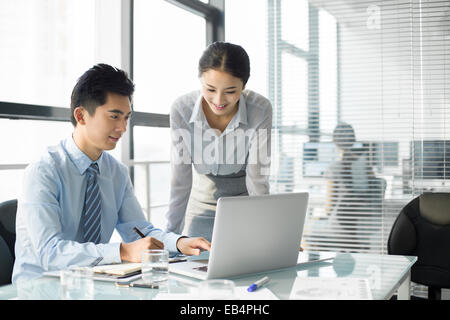 I giovani uomini di affari con computer portatile in ufficio Foto Stock