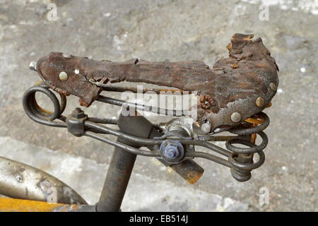 Vicino sul sellino di bicicletta bruciato in strada Foto Stock