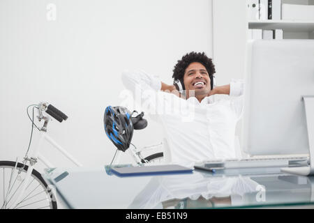 Designer rilassato con cuffie Pendente ritornare nella sua sedia Foto Stock
