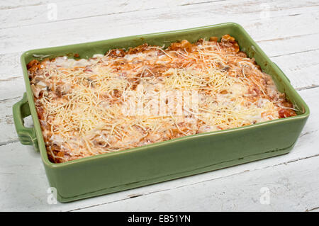 Preparazione di lasagne in una verde piatto sul tavolo bianco Foto Stock