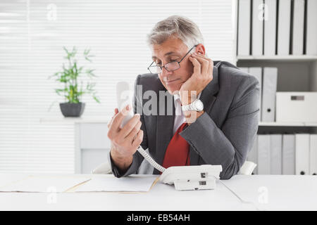 Imprenditore sorridente messa in attesa Foto Stock