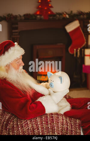 Santa Claus holding salvadanaio a natale Foto Stock