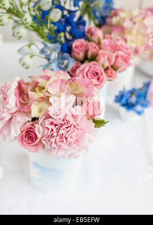 Delphinium blu, rosa rose, ortensie, garofano in scatole decorate con dipinti acquerello su carta - sfondo bianco Foto Stock