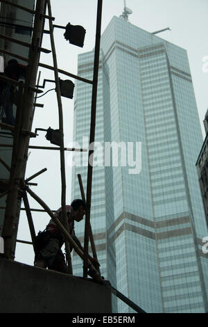 Impalcatura operaio sul sito di costruzione in silhouette, Hong-Kong Foto Stock