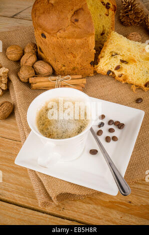 Panettoni artigianali con una tazza di cappuccino e alcuni ingredienti Foto Stock