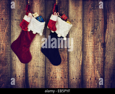 Calza di Natale appeso contro il legno rustico sfondo Foto Stock