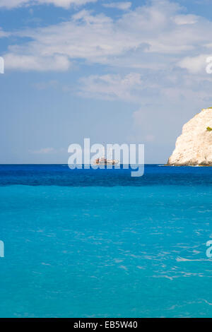 Anafonitria, Zante, Isole Ionie, Grecia. Vista attraverso le acque turchesi della baia di Navagio, escursioni barca sull orizzonte. Foto Stock