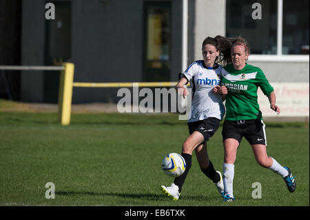 Andando per la sfera: due giovani donne ragazze che giocano a calcio calcio, competere impegnativo per il calcio REGNO UNITO Foto Stock