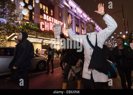 Il centro di Londra, Regno Unito. Il 26 novembre 2014. I dimostranti prendere per le strade del centro di Londra dopo aver dimostrato di fronte all'Ambasciata Americana, Londra, contro la decisione da parte di una giuria di non caricare funzionario di polizia Darren Wilson per la ripresa di dead Michael Brown, un inerme 18-anno-vecchio, in una zona residenziale a lato strada di Ferguson il 9 agosto. Manifestanti hanno cantato "Hands Up non sparare e 'chi le strade delle nostre strade". Foto Stock