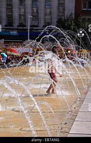 Gli adolescenti godendo paddling in una fontana fuori casa Consiglio noto anche come il municipio nella piazza del vecchio mercato. Foto Stock