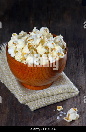 Ciotola di popcorn isolato sul vecchio sfondo di legno Foto Stock