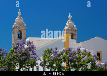Il Portogallo, Algarve, Faro, Igreja do Carmo jacarandá e alberi in fiore Foto Stock