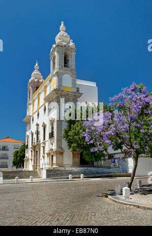 Il Portogallo, Algarve, Faro, Igreja do Carmo jacarandá e alberi in fiore Foto Stock