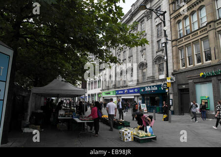 Visualizzare, per la creazione di negozi, gente che passeggia, shopping market bancarella vendendo verdure, Piccadiily giardini, Oldham Street, Manchester Foto Stock