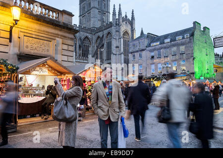 Bath, Regno Unito, 27 novembre 2014. Quando scende la notte folle di acquirenti visitare il Mercato di Natale sono fotografati davanti all Abbazia di Bath. Credito: lynchpics/Alamy Live News Foto Stock