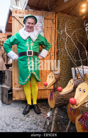 Bath, Regno Unito, 27 novembre 2014. Un titolare di stallo vendono renne di legno è raffigurato accanto alla sua pressione di stallo per il giorno di apertura del bagno mercatino di Natale. Credito: lynchpics/Alamy Live News Foto Stock