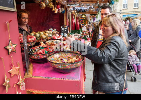 Bath, Regno Unito, 27 novembre 2014. Una donna è raffigurata la visualizzazione di decorazioni di Natale su un mercato in stallo per il giorno di apertura del bagno mercatino di Natale. Credito: lynchpics/Alamy Live News Foto Stock