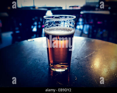 Vintage cercando pinta di inglese bitter ale in un pub Foto Stock