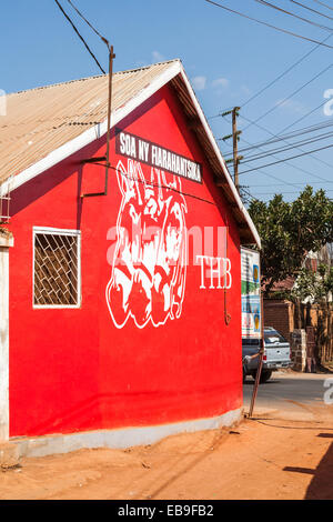 Segno rosso dipinta su un muro per la pubblicità delle popolari locali tre cavalli birra (THB), Antananarivo, o Tana, la città capitale del Madagascar Foto Stock
