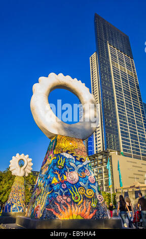 'I guardiani' scultura di Simon Rigg, contro alti grattacieli, Southbank Melbourne, Australia. Le piastrelle di ceramica e pietra di argilla 6.7 Foto Stock