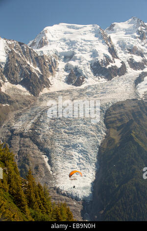 Un paraponter davanti al Ghiacciaio Bossons sul Mont Blanc al di sopra di Chamonix, Francia. Foto Stock