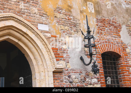 Apparecchiatura di illuminazione medievale sul vecchio muro di mattoni di una casa Foto Stock