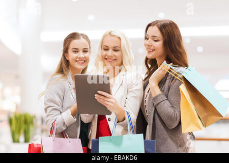 Felice di giovani donne con tablet pc e borse per lo shopping Foto Stock