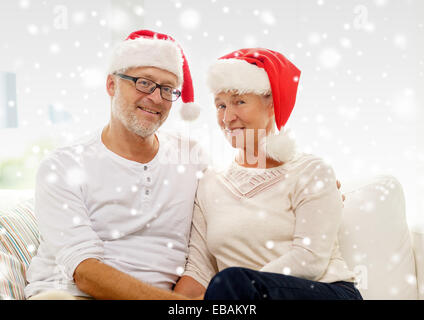 Felice coppia senior in santa helper cappelli a casa Foto Stock