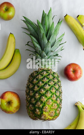 L'ananas, le mele e le banane sopra un panno bianco, sopra visualizza Foto Stock