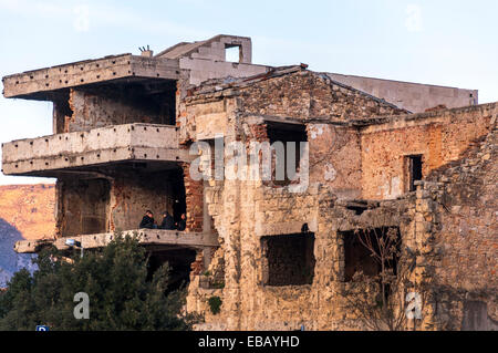 Gli uomini siedono in un piano superiore di una guerra edificio danneggiato a Mostar, in Bosnia ed Erzegovina Foto Stock