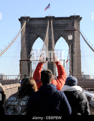 I turisti prendono selfie foto di se stessi con telefono mobile sul ponte di Brooklyn, Manhattan New York STATI UNITI D'AMERICA Foto Stock