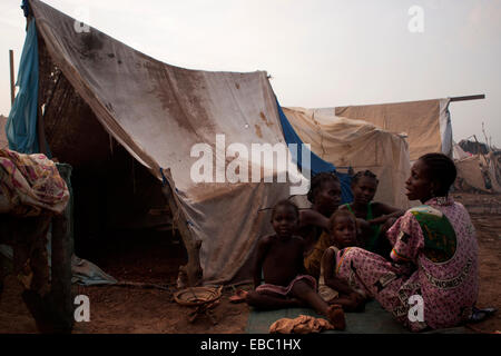 Una famiglia si trova al di fuori della loro tenda realizzato localmente in Mpoko per il campo per sfollati interni, Bangui Repubblica Centrale Africana Foto Stock