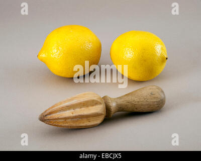 Due limoni con legno estrattore di succo Foto Stock