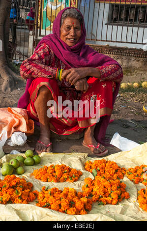 Venditore a vendere calendula ghirlande e frutta sotto Swayambhunath Stupa, Kathmandu Foto Stock