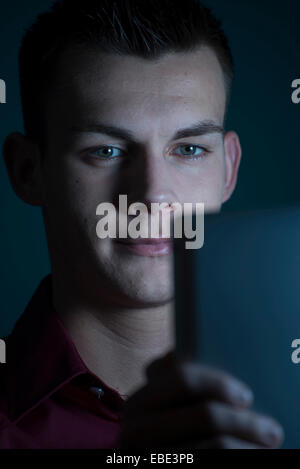 Giovane uomo guardando il computer Tablet, Studio Shot Foto Stock