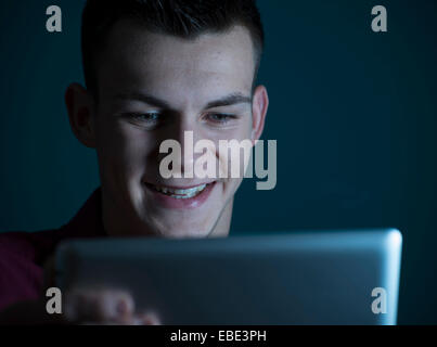 Giovane uomo guardando il computer Tablet, Studio Shot Foto Stock
