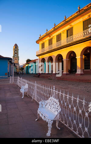 White sedie in metallo e una recinzione nella parte anteriore del Museo Romantico con San Francisco convento in background, Trinidad, Cuba, Caraibi Foto Stock