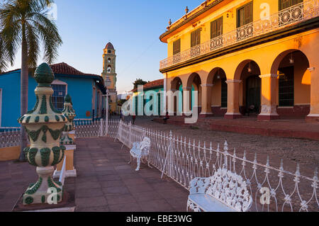 White sedie in metallo e una recinzione, Museo Romantico e la Torre di San Francisco convento in background, Trinidad, Cuba, Caraibi Foto Stock