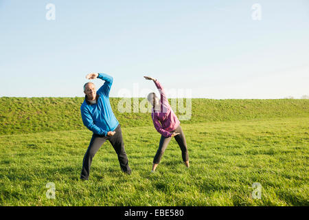 Coppia adulta che esercitano nel campo, Germania Foto Stock